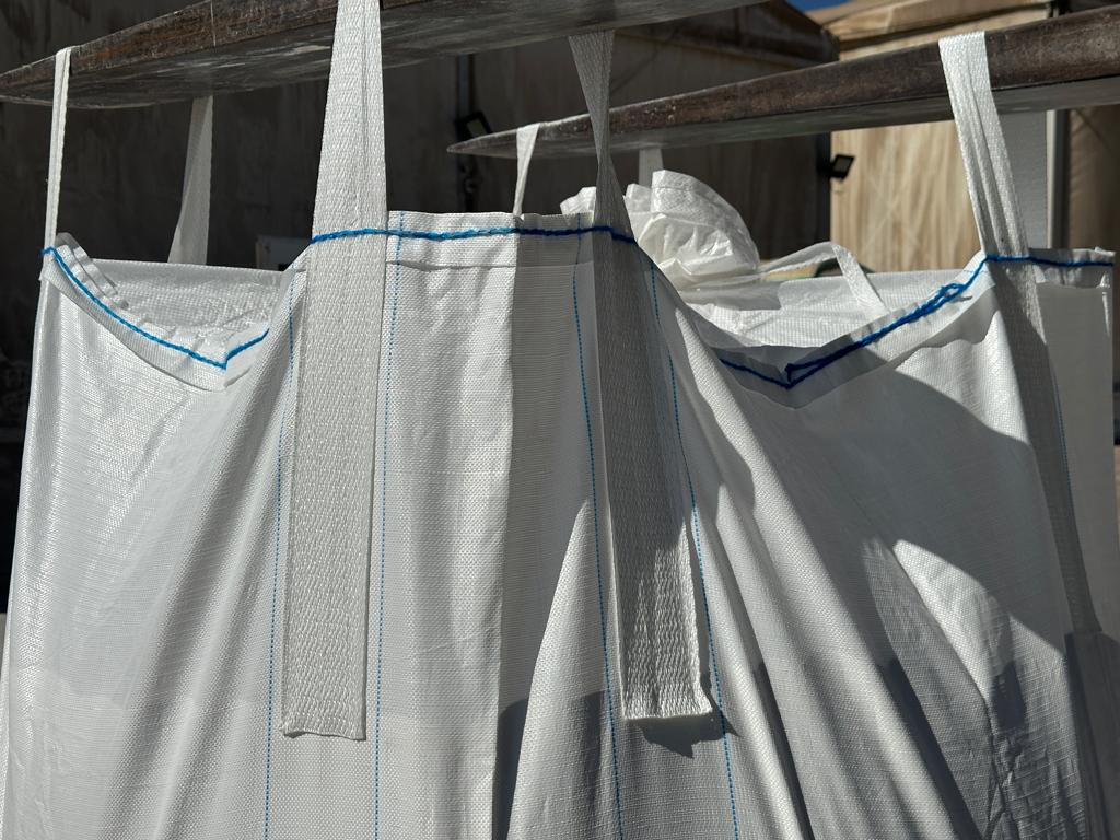 Bolsas grandes de almacenamiento colgadas en una estructura de soporte.